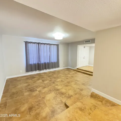 a view of a room with a window and wooden floor