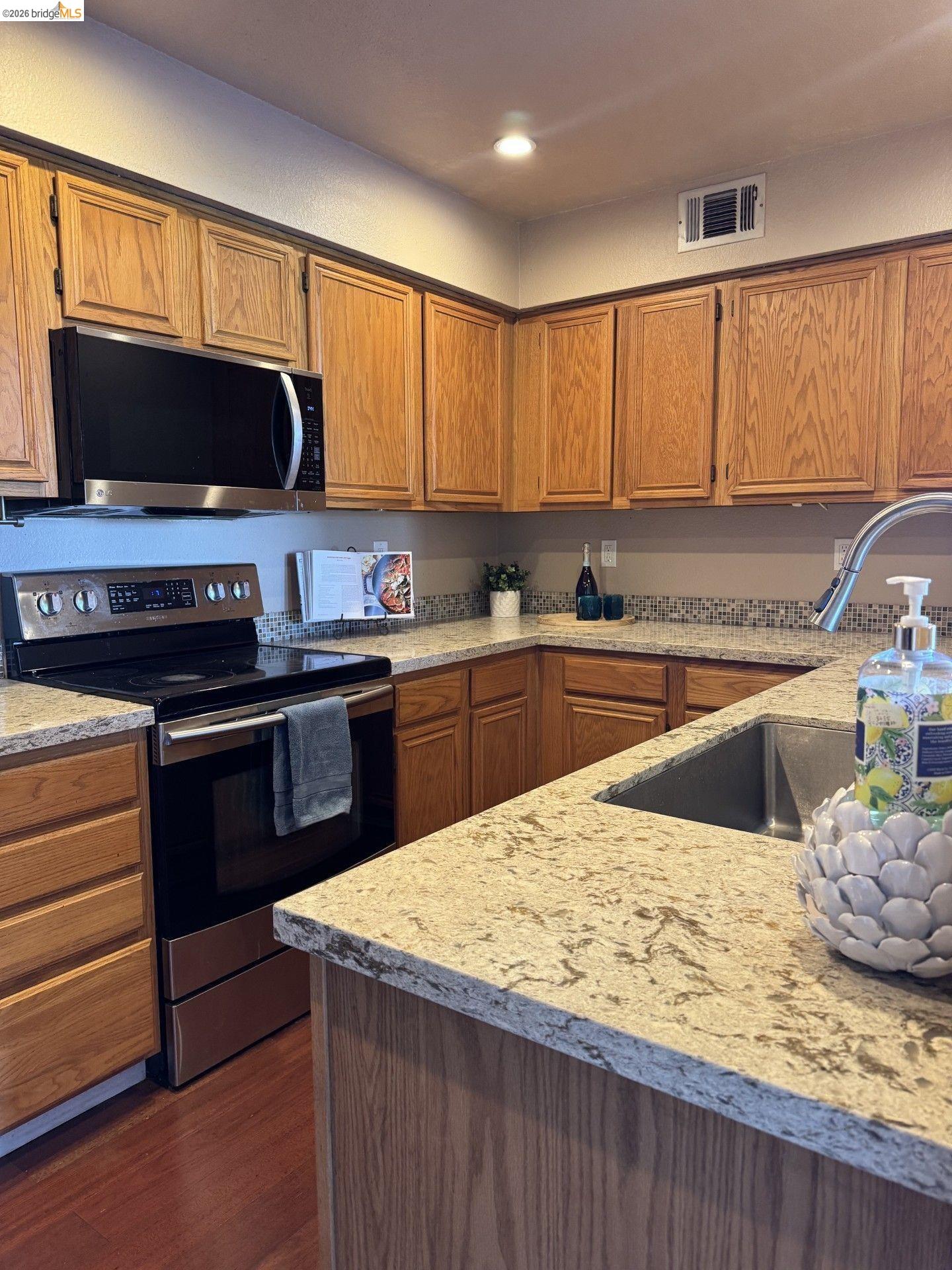 3623 Wells Road Oakley, CA 94561 - Photo 24 of 75 Kitchen featuring wood cabinetry, light-toned countertops, stainless steel appliances, a built-in microwave, and a undermount sink