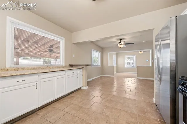 a large white kitchen with a sink and cabinets