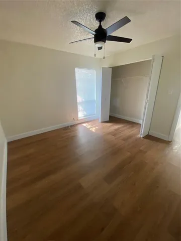 an empty room with a ceiling fan and carpet