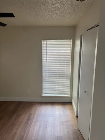 an empty room with wooden floor and window