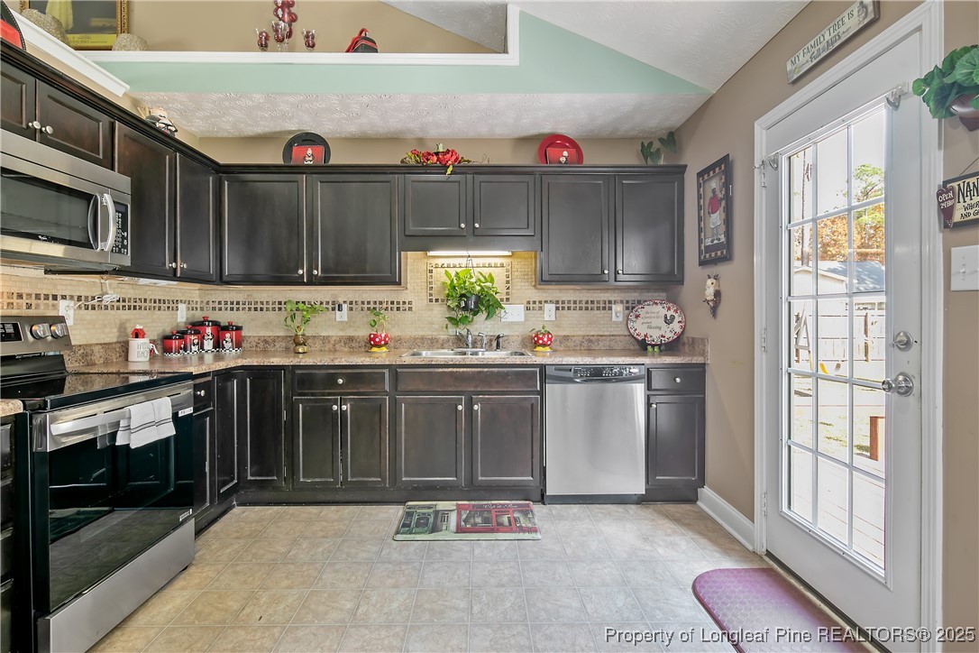 245 Apple Tree Circle Raeford, NC 28376 - Photo 15 of 41 a kitchen with granite countertop a stove a sink and a microwave