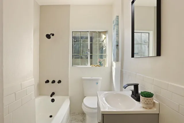 a bathroom with a sink a toilet and a mirror