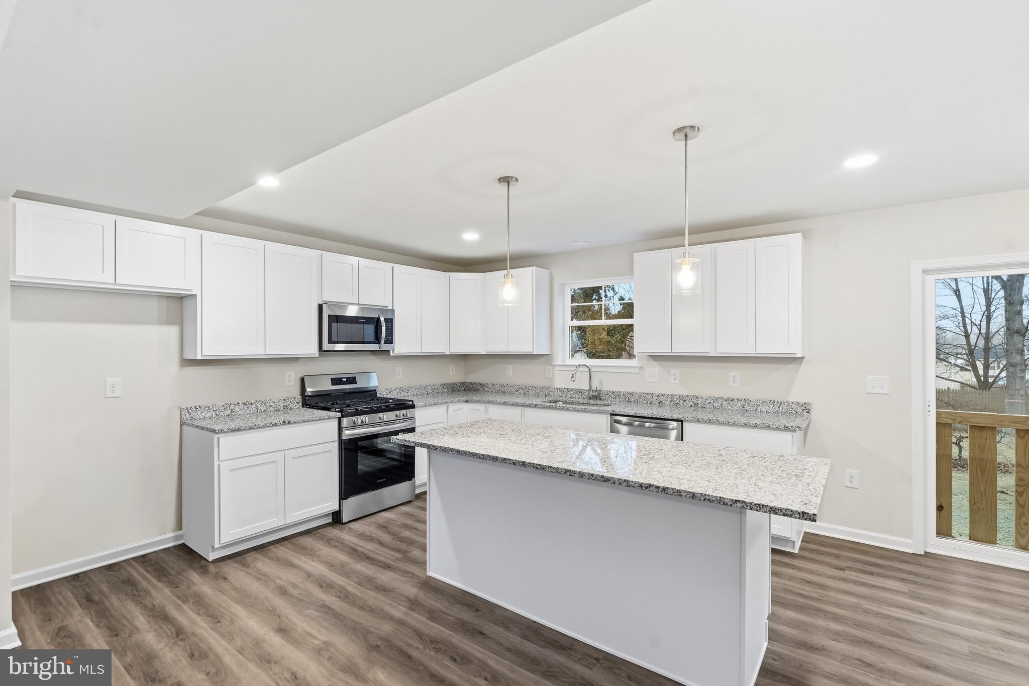 105 West Washington Avenue Magnolia, NJ 08049 - Photo 11 of 28 a kitchen with stainless steel appliances granite countertop a sink a stove a refrigerator and island with wooden floor