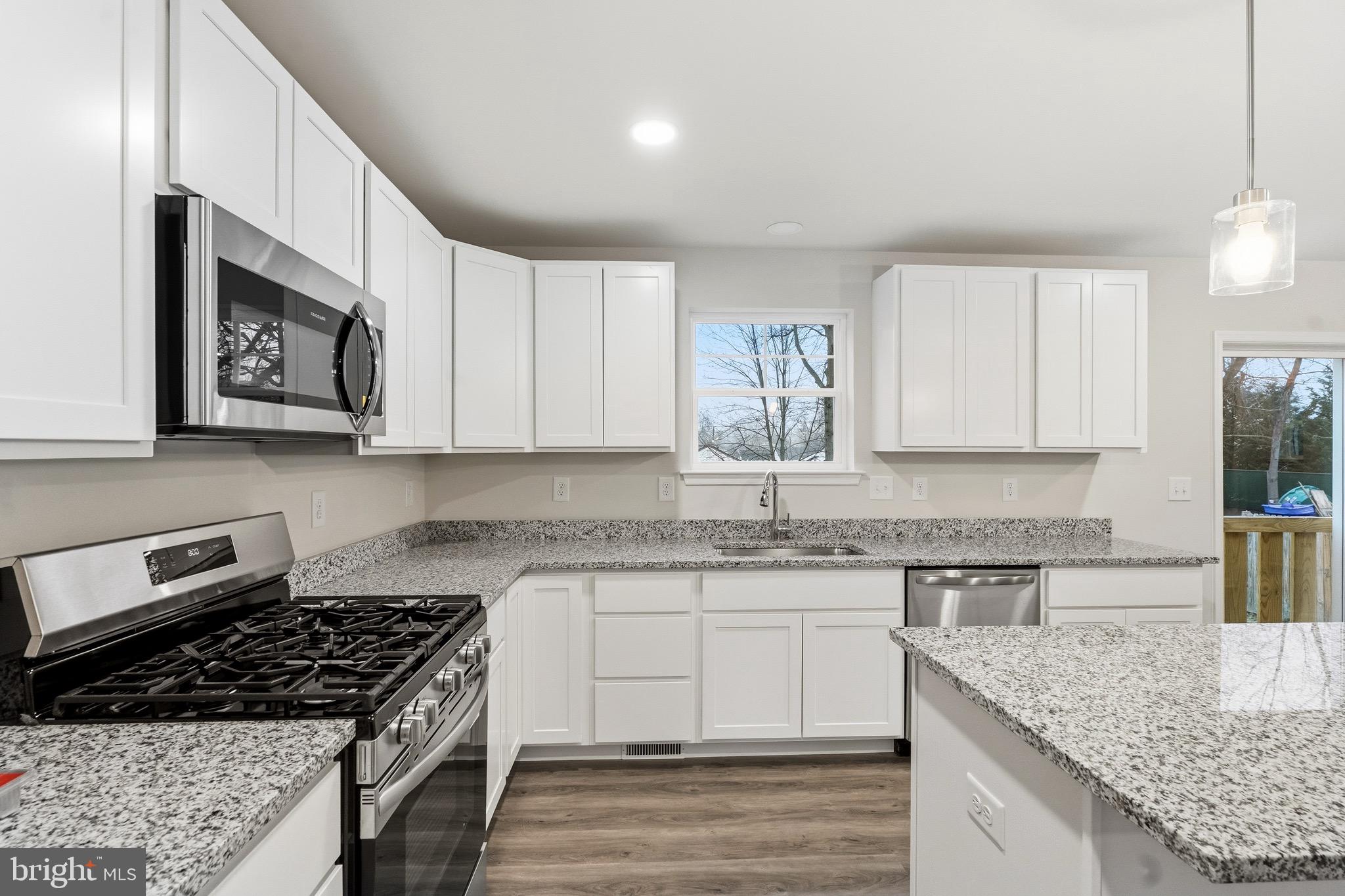105 West Washington Avenue Magnolia, NJ 08049 - Photo 13 of 31 a kitchen with stainless steel appliances granite countertop a stove a sink dishwasher and cabinets with wooden floor