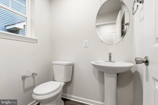 a bathroom with a toilet a sink and mirror