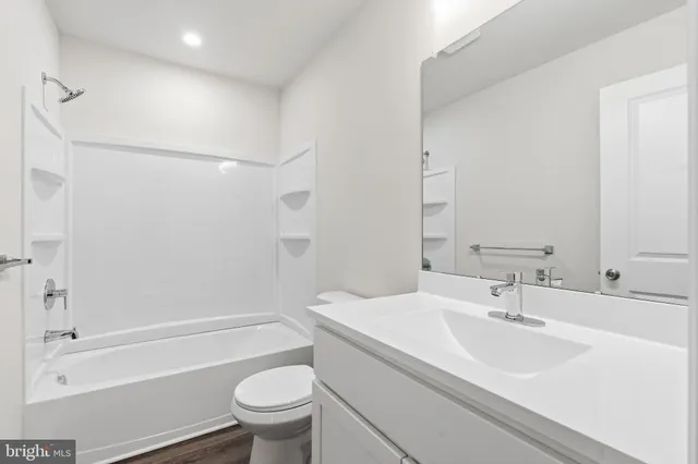 a bathroom with a sink a toilet and a large mirror