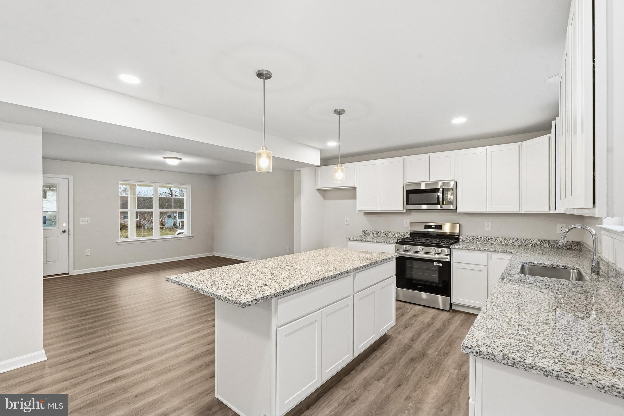 105 West Washington Avenue Magnolia, NJ 08049 - Photo 7 of 28 a large kitchen with stainless steel appliances granite countertop a stove a sink dishwasher and a oven with wooden floors
