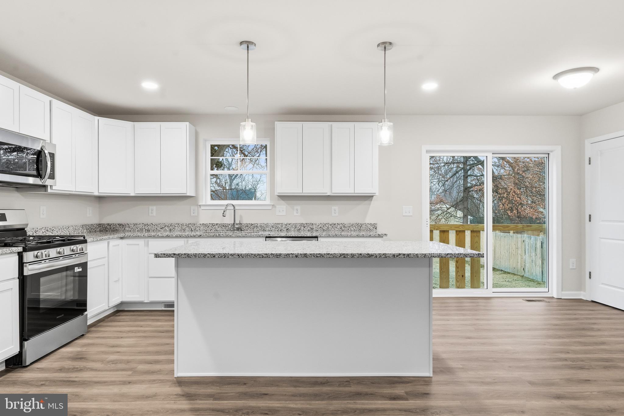 105 West Washington Avenue Magnolia, NJ 08049 - Photo 8 of 31 a kitchen with stainless steel appliances granite countertop a stove a sink dishwasher a refrigerator and a microwave oven with wooden floor