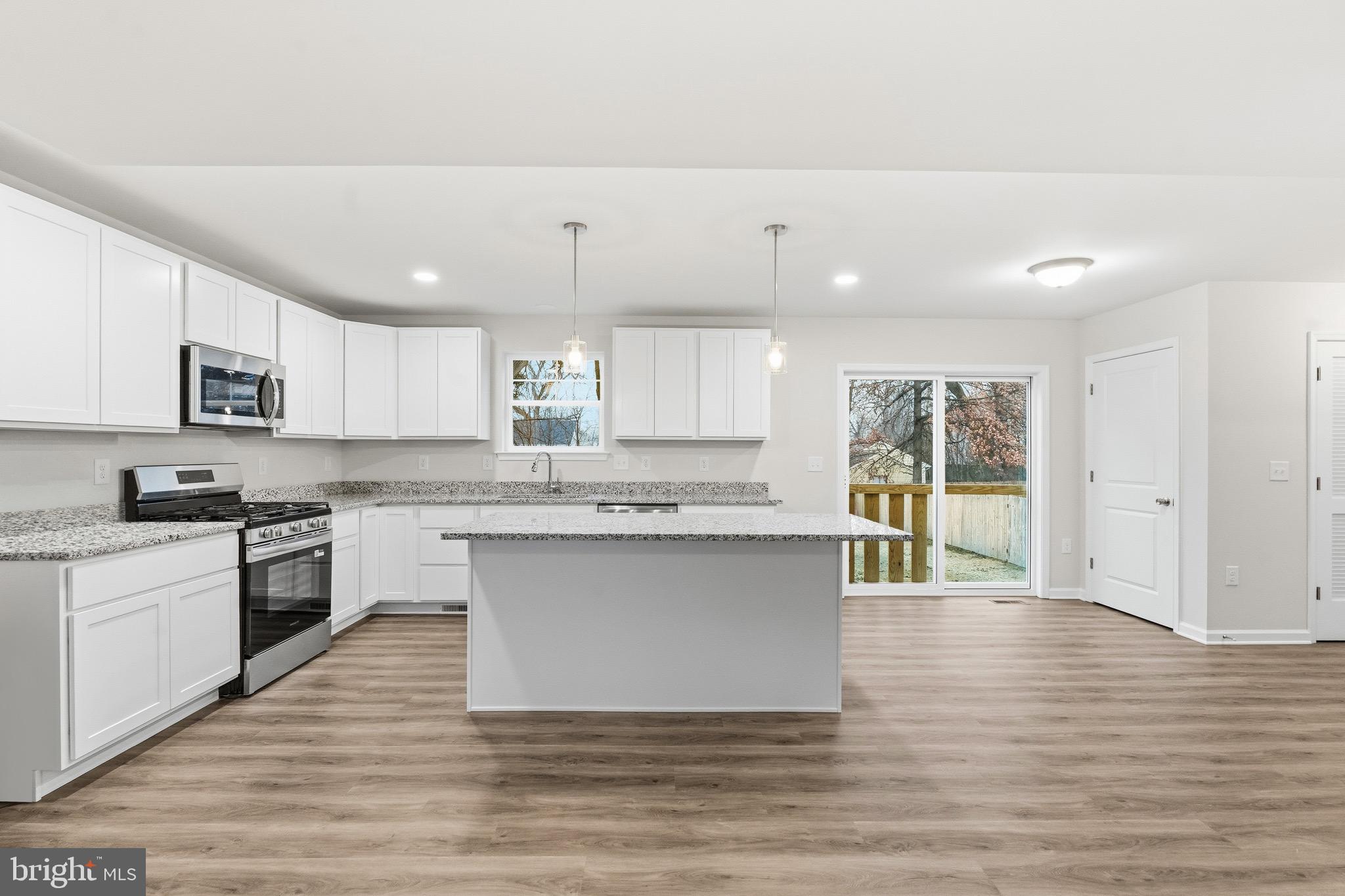 105 West Washington Avenue Magnolia, NJ 08049 - Photo 10 of 28 a large kitchen with cabinets wooden floor and stainless steel appliances