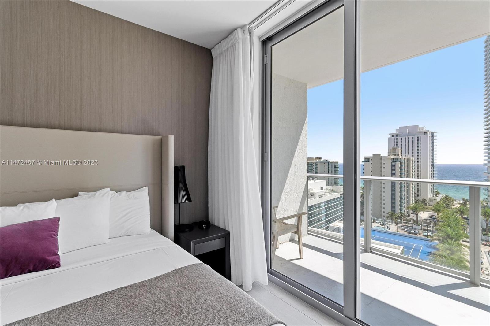 4010 South Ocean Drive, Unit R1107 Hollywood, FL 33019 - Photo 13 of 25 a bedroom with a bed and a large window