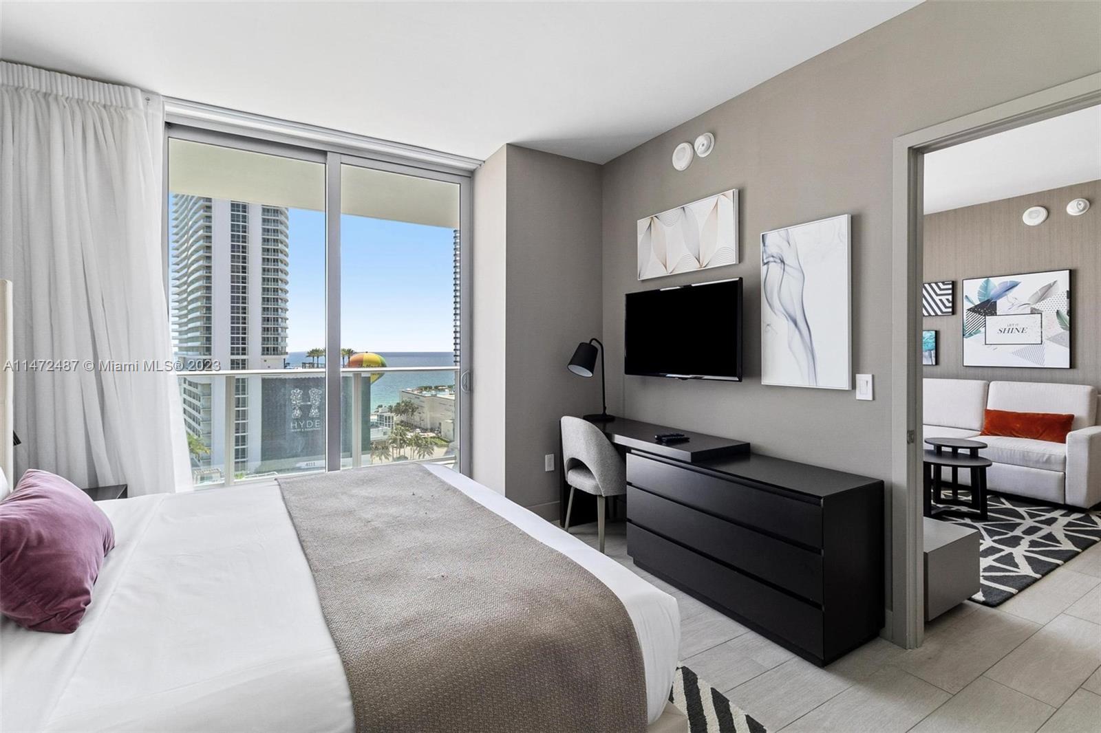 4010 South Ocean Drive, Unit R1107 Hollywood, FL 33019 - Photo 14 of 25 a bedroom with a bed and a flat tv screen on dresser