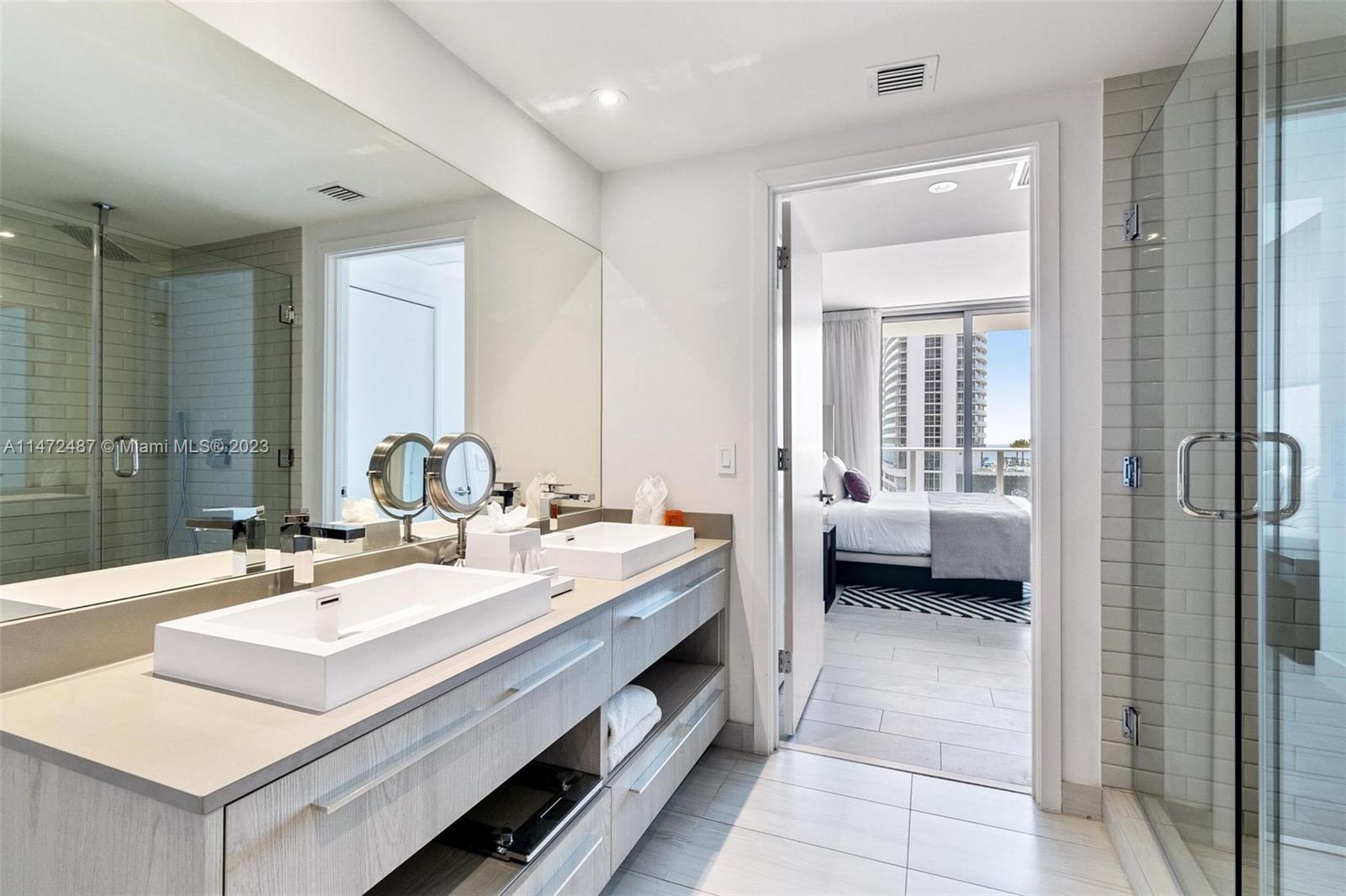 4010 South Ocean Drive, Unit R1107 Hollywood, FL 33019 - Photo 19 of 25 a en suite bathroom with a double vanity sink a mirror and a shower