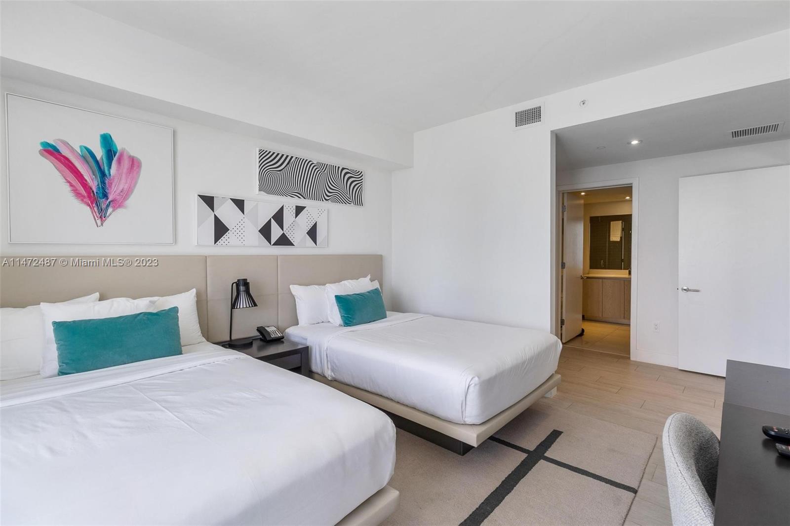 4010 South Ocean Drive, Unit R1107 Hollywood, FL 33019 - Photo 21 of 25 a bedroom with two beds and painting on the wall