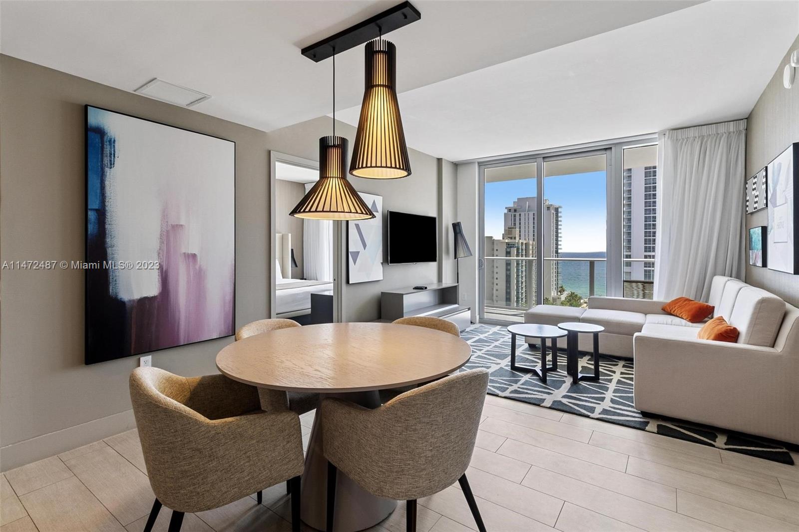 4010 South Ocean Drive, Unit R1107 Hollywood, FL 33019 - Photo 4 of 25 a living room with patio furniture and a flat screen tv