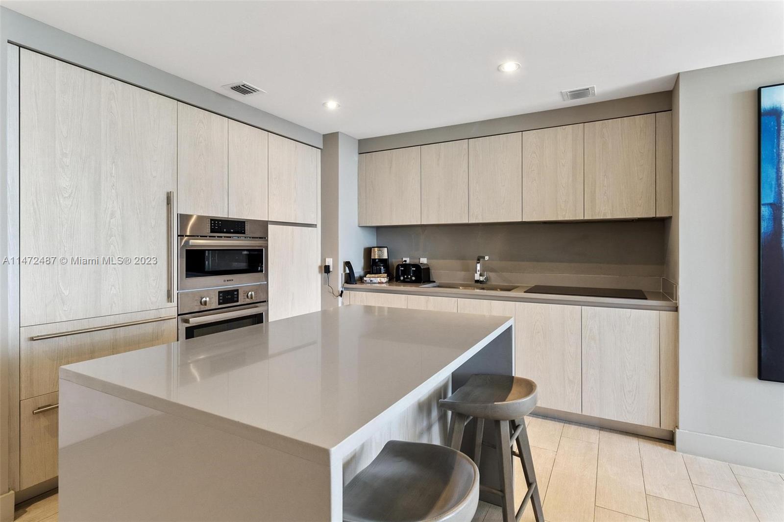 4010 South Ocean Drive, Unit R1107 Hollywood, FL 33019 - Photo 7 of 25 a kitchen with stainless steel appliances a stove a sink a microwave and cabinets