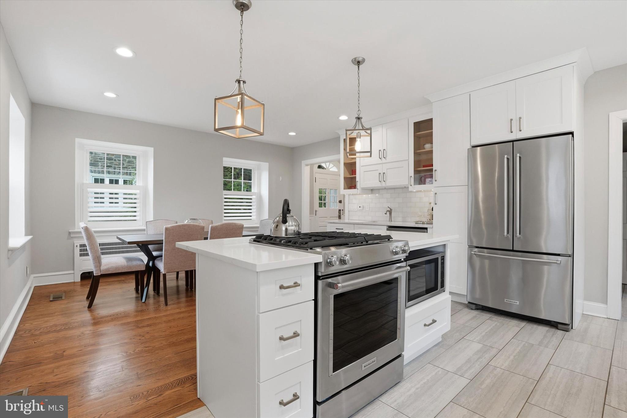 507 Murdoch Road Philadelphia, PA 19119 - Photo 18 of 52 a kitchen with stainless steel appliances granite countertop a stove a refrigerator a oven a dining table and chairs with wooden floor