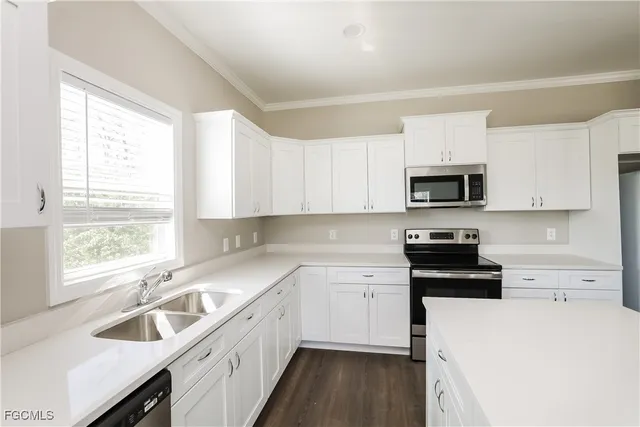a kitchen with a sink a stove a microwave a counter space and cabinets
