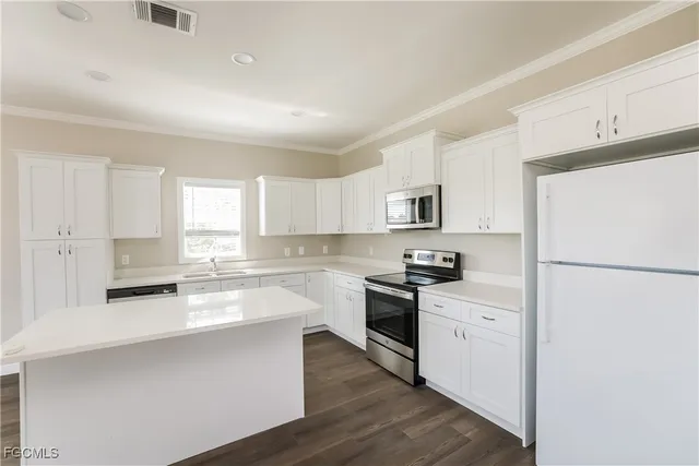 a kitchen with granite countertop a refrigerator stove top oven and sink