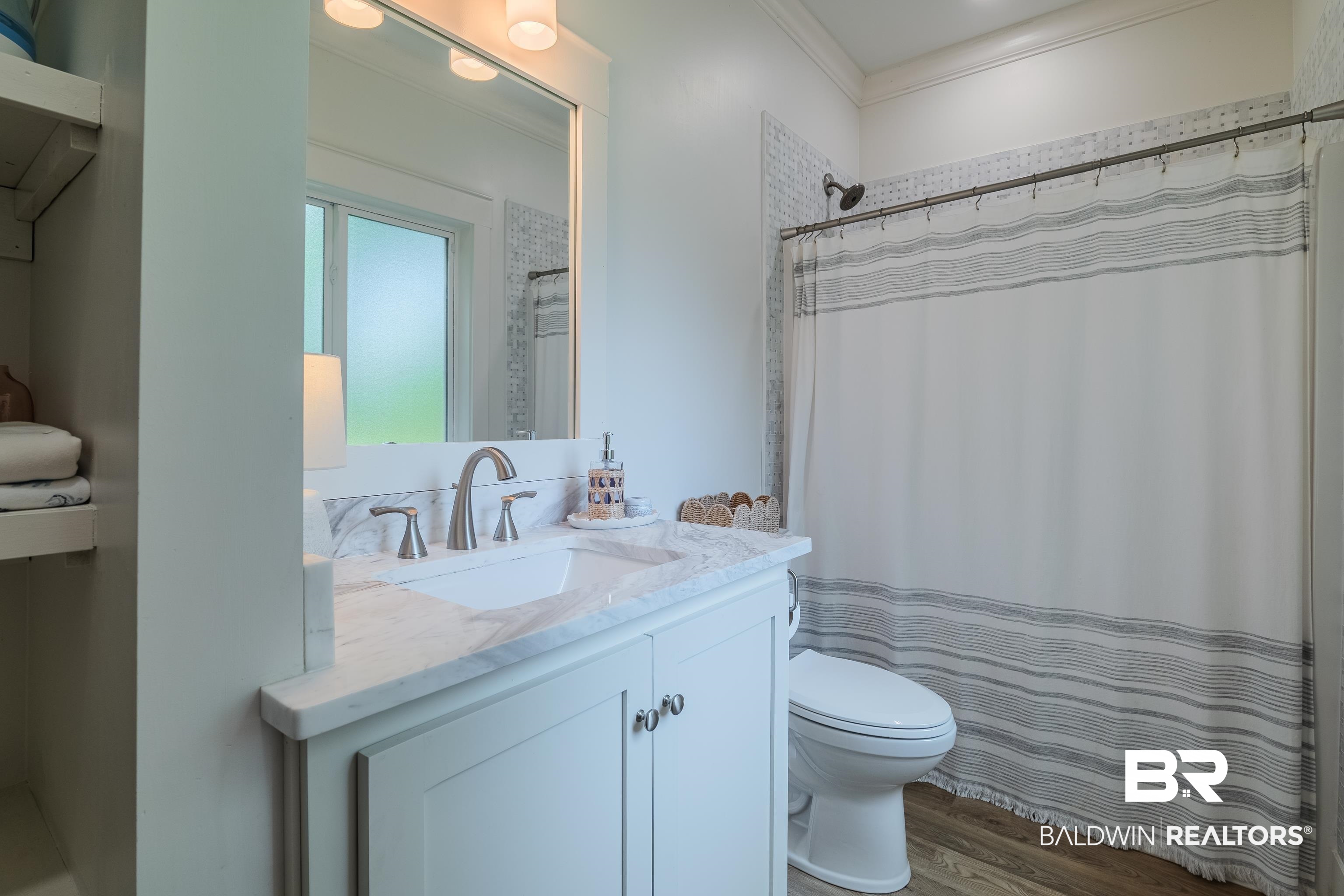 19121 Boothe Road Fairhope, AL 36532 - Photo 22 of 41 Bathroom with vanity, ornamental molding, dark wood finished floors, and a shower with shower curtain