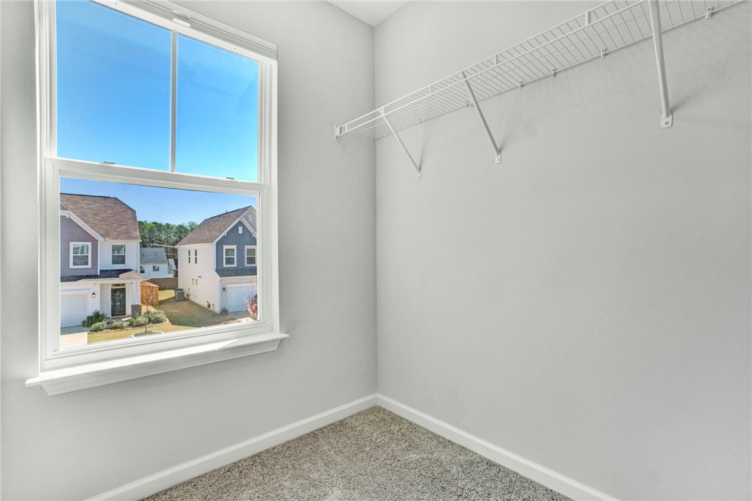 270 Pendergast Road Greenville, SC 29605 - Photo 25 of 43 A well-lit bedroom features ample storage with wire shelving and a bright window offering neighborhood views.