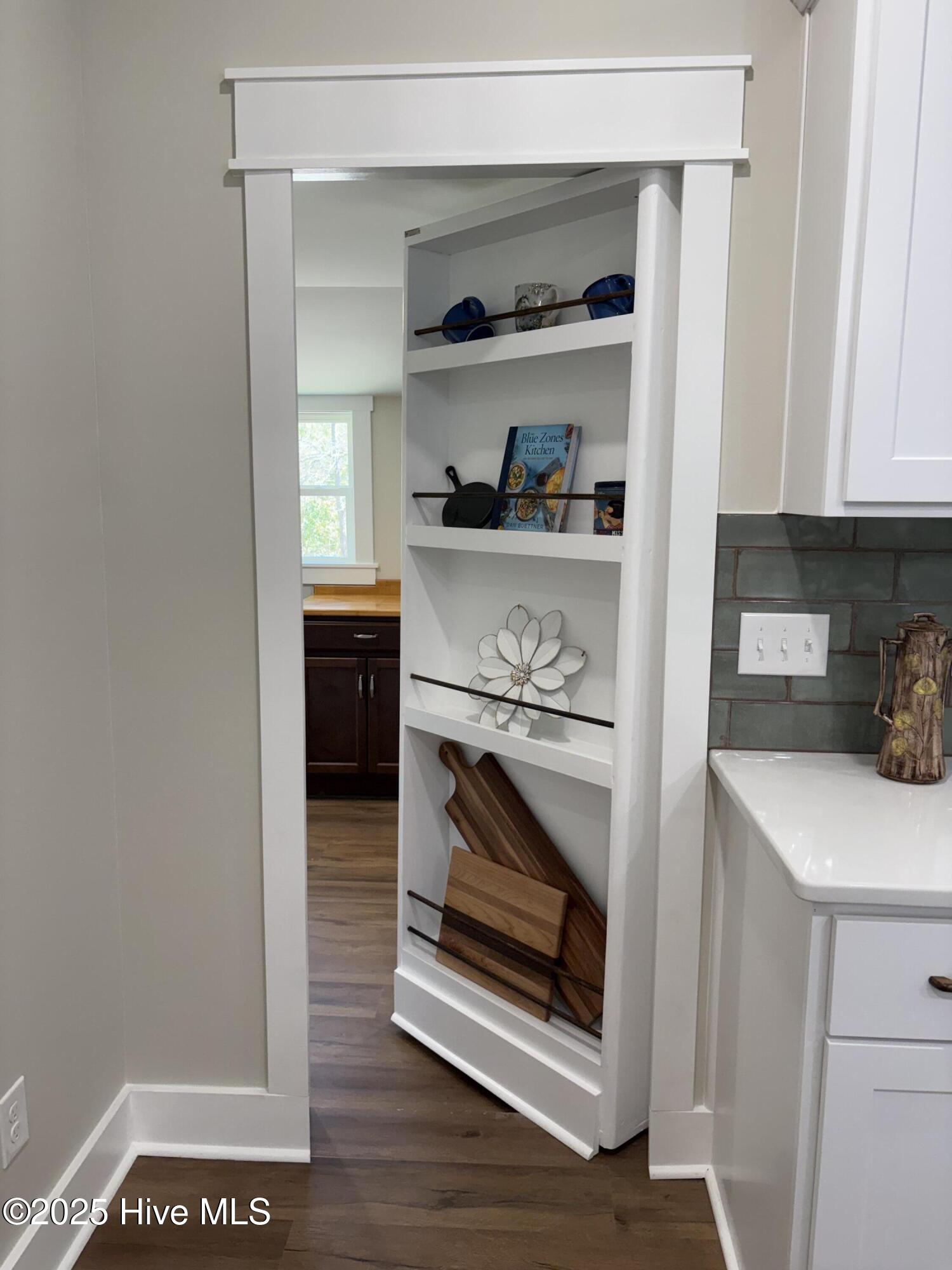 599 Bitmore Road Whiteville, NC 28472 - Photo 10 of 23 Custom built-in cabinet doubles as a hidden door, offering a stylish and discreet entrance to the laundry/pantry area.