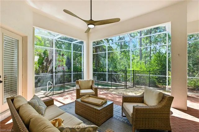 a living room with furniture and a floor to ceiling window