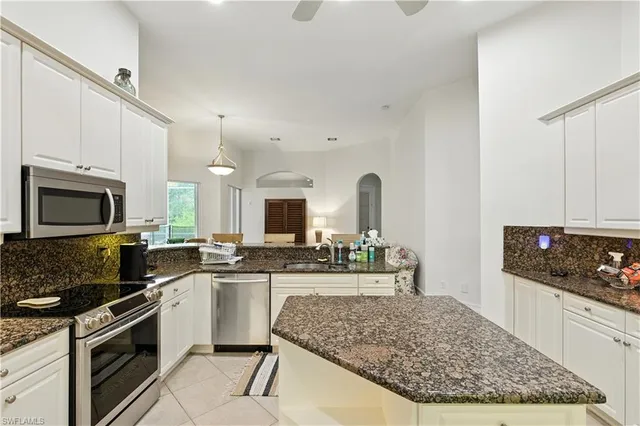 a kitchen with stainless steel appliances granite countertop a stove oven and a white cabinets