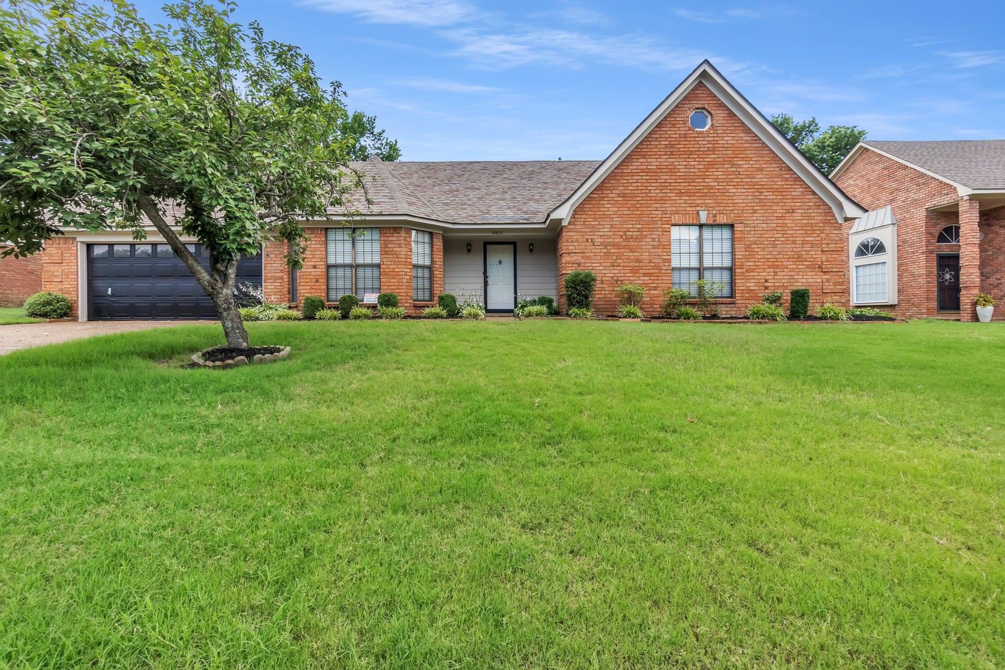 6613 Stephan Ridge Drive Bartlett, TN 38135 - Photo 2 of 24 Brick facade residence featuring an attached garage with a dark door, a peaked architectural element with an oculus window, and a bay window