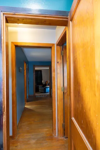 a view of a hallway with wooden floor and a living room