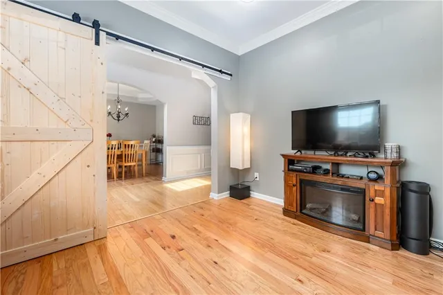 a view of a livingroom with wooden floor and a flat screen tv