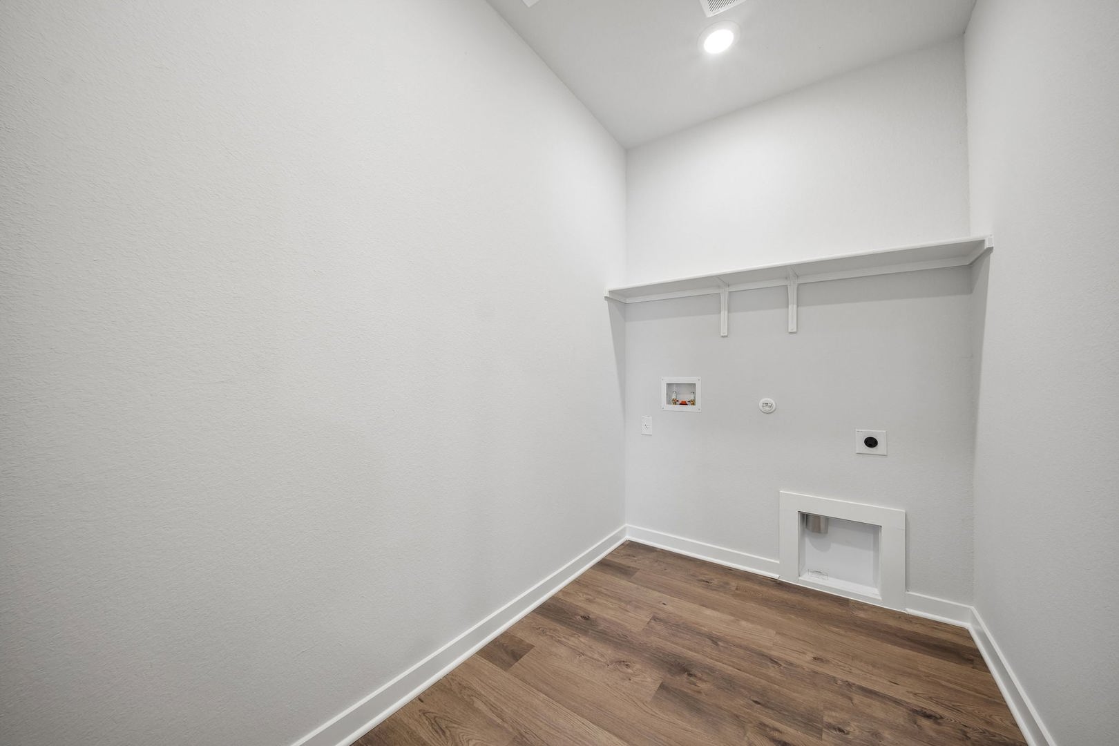 113 Two Bits Lane Elgin, TX 78621 - Photo 17 of 23 A dedicated utility space with robust wood flooring offers convenience for household tasks.