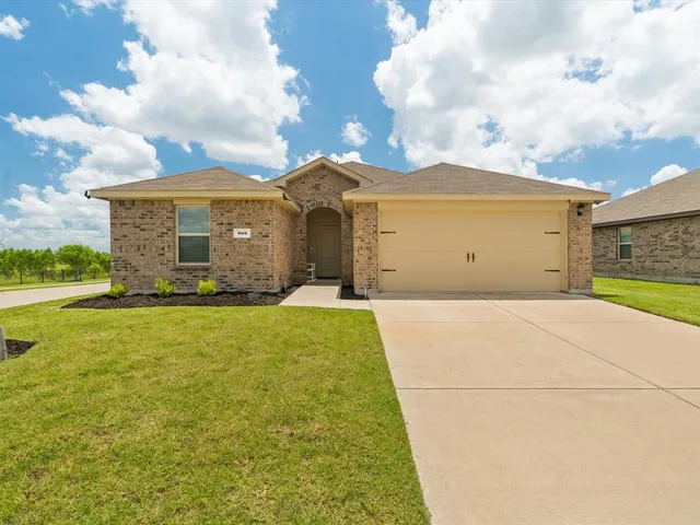 a view of a big house with a big yard and large tree