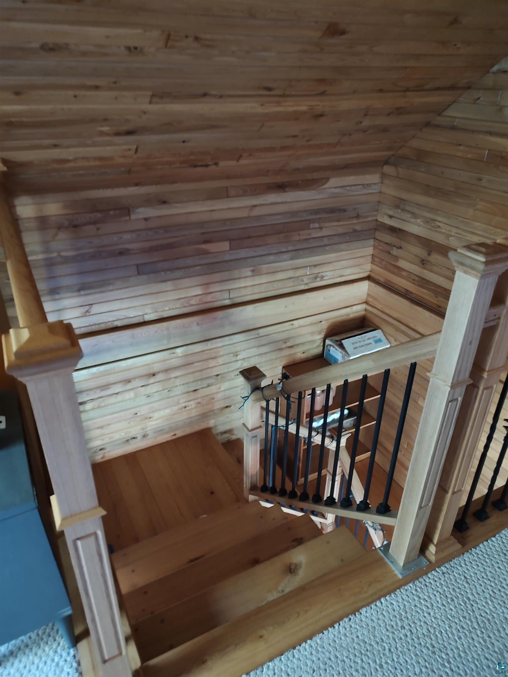 2585 Hautala Road Iron River, WI 54847 - Photo 9 of 28 Solid wood staircase with wrought iron balusters and natural wood newel posts