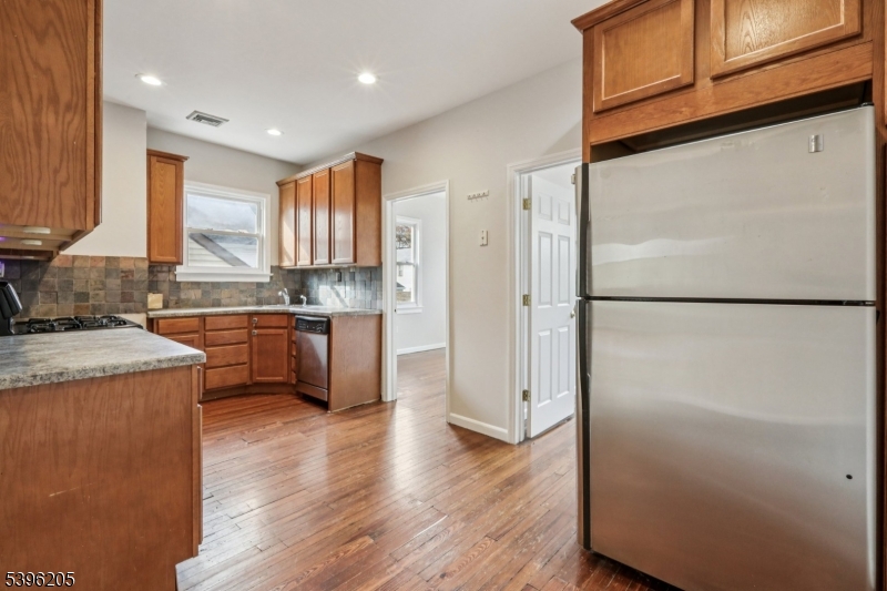 507 Bloomfield Avenue Nutley, NJ 07110 - Photo 12 of 26 a kitchen with stainless steel appliances granite countertop a refrigerator a sink dishwasher a stove with wooden floor