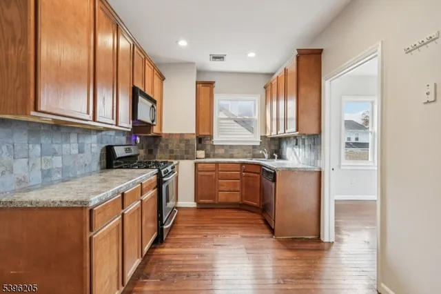 a kitchen with stainless steel appliances granite countertop a stove a sink dishwasher and a refrigerator