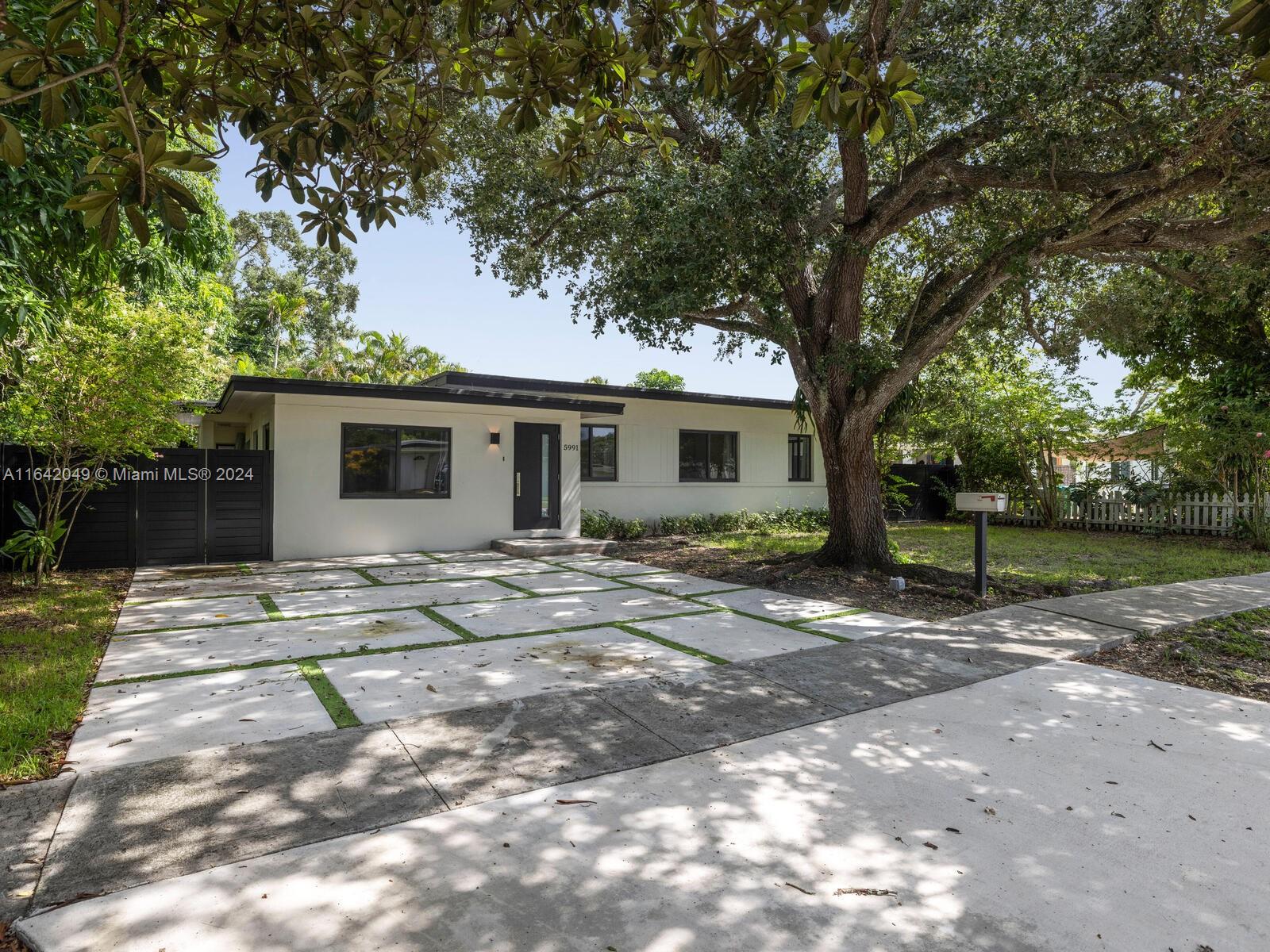 5991 Southwest 45th Street Miami, FL 33155 - Photo 1 of 35 a view of a house with backyard and a tree