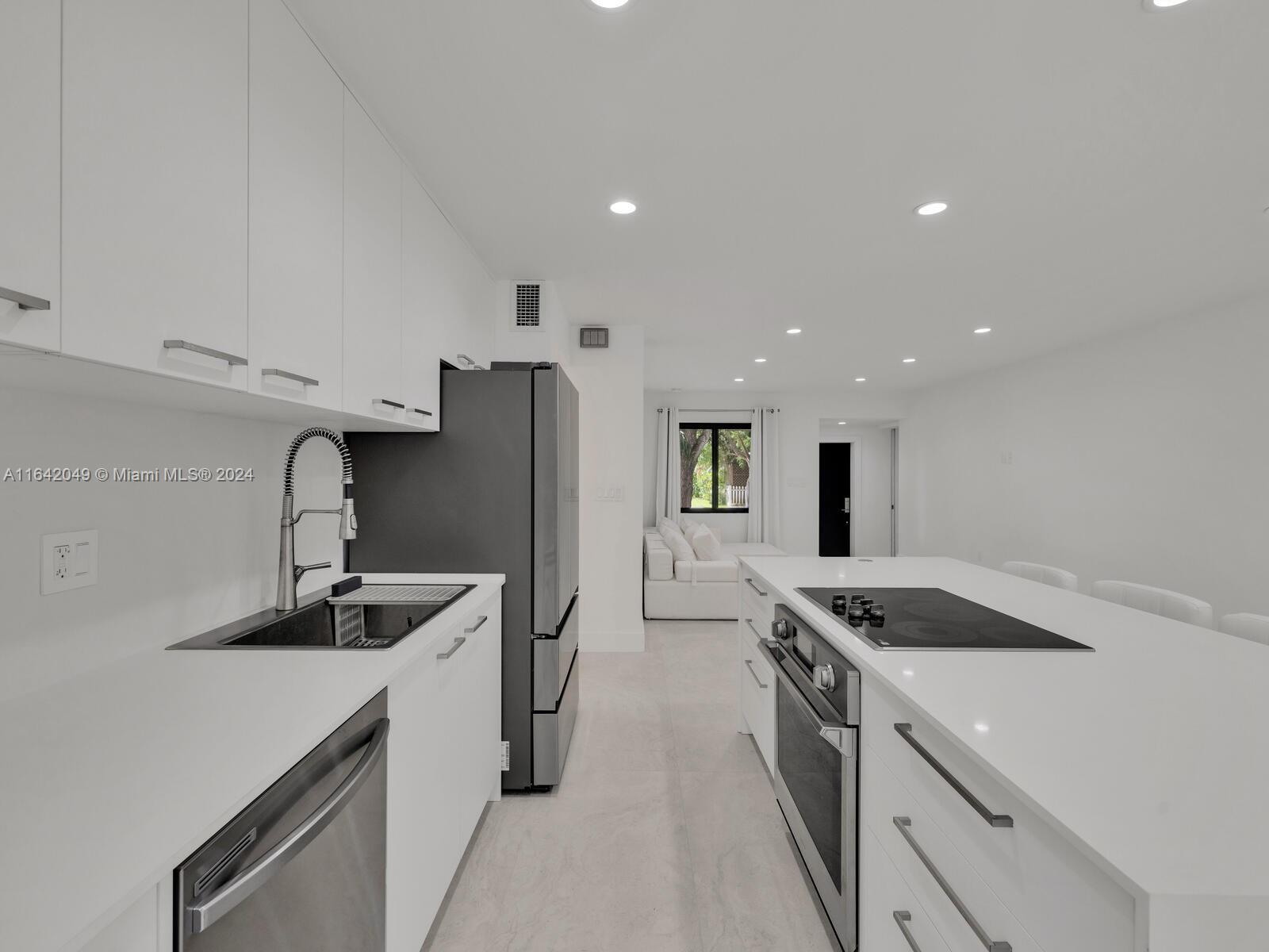 5991 Southwest 45th Street Miami, FL 33155 - Photo 11 of 35 a kitchen with stainless steel appliances granite countertop a sink stove and refrigerator