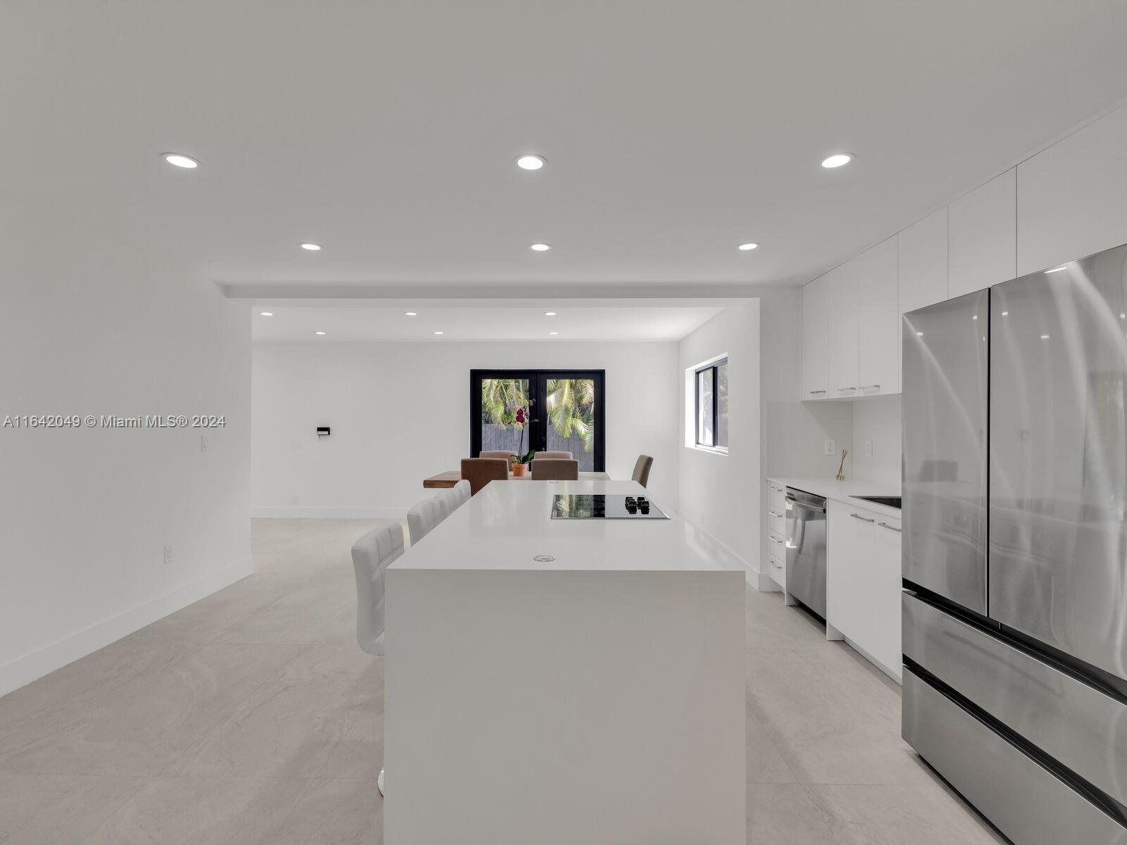 5991 Southwest 45th Street Miami, FL 33155 - Photo 15 of 35 a large white kitchen with a sink a refrigerator and a stove