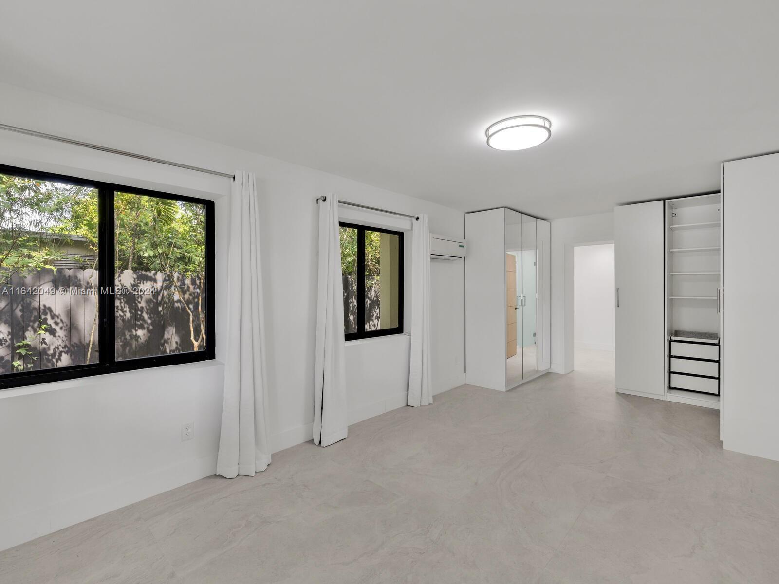5991 Southwest 45th Street Miami, FL 33155 - Photo 16 of 35 an empty room with windows and closet