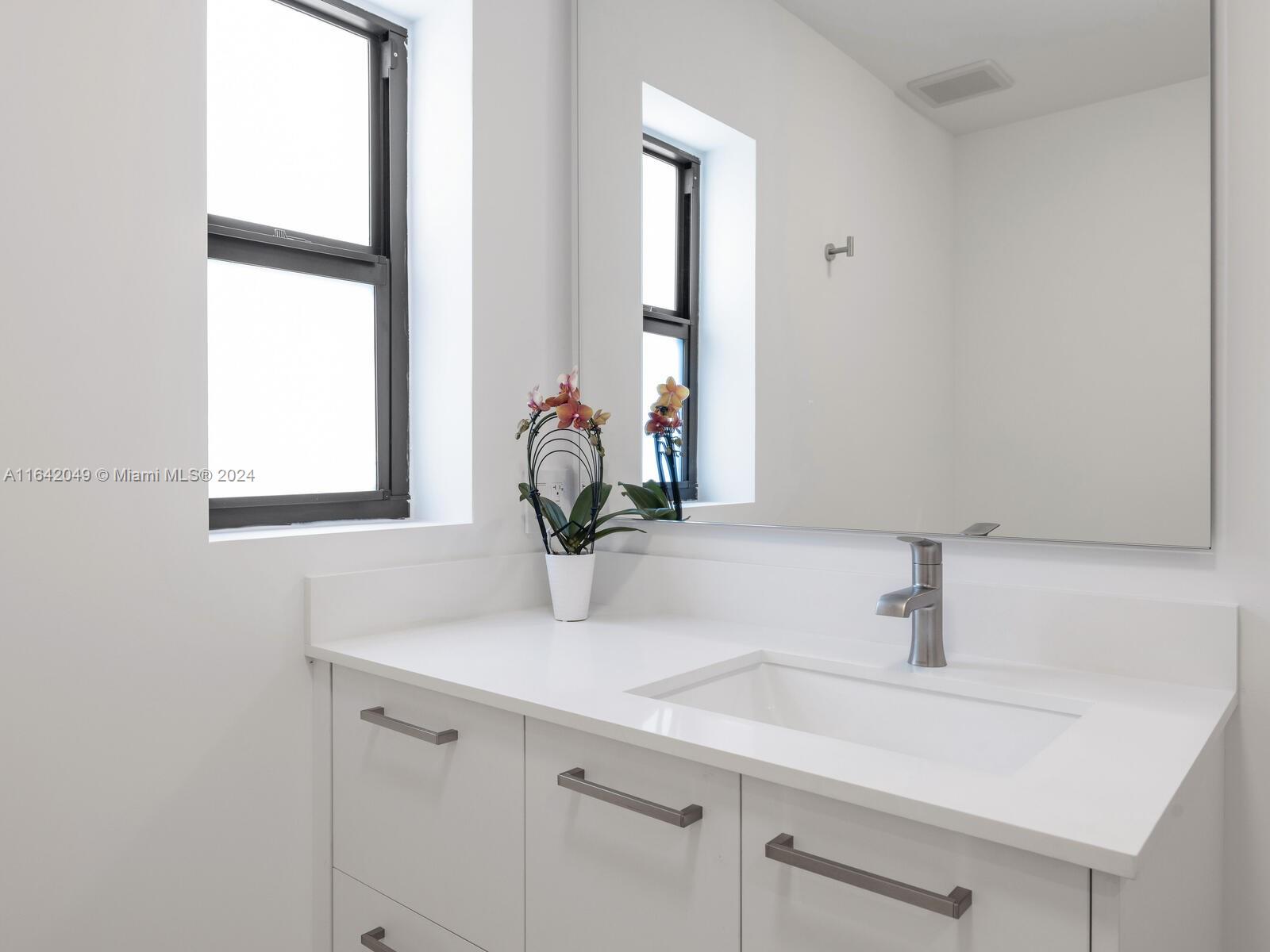 5991 Southwest 45th Street Miami, FL 33155 - Photo 24 of 35 a bathroom with a sink and a mirror