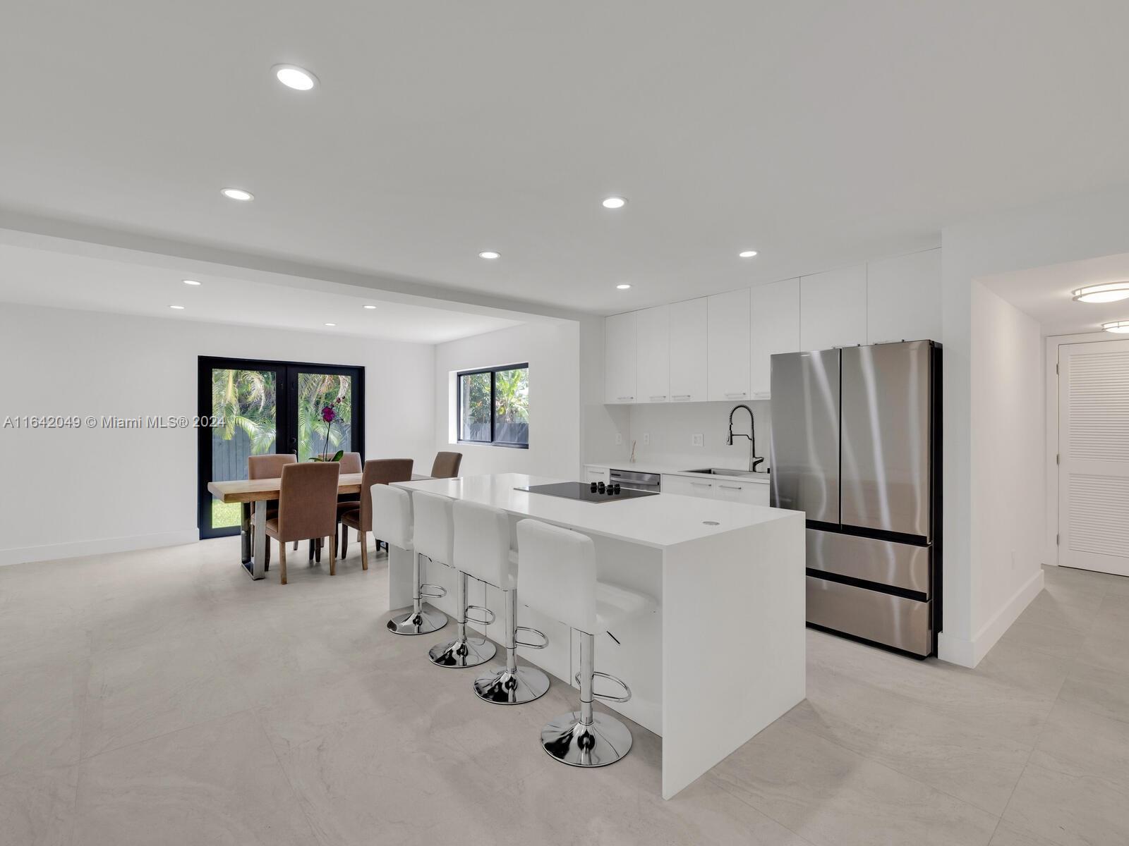 5991 Southwest 45th Street Miami, FL 33155 - Photo 3 of 35 a kitchen with refrigerator and chairs