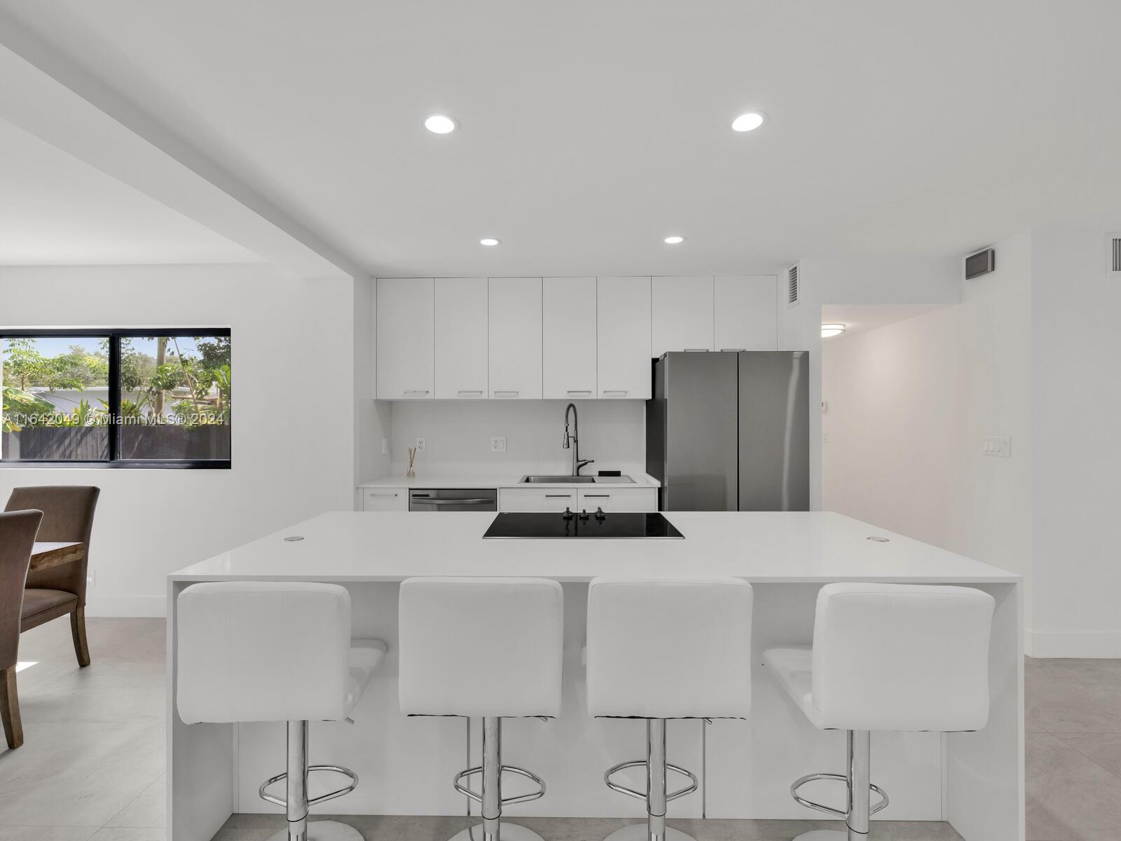 5991 Southwest 45th Street Miami, FL 33155 - Photo 7 of 35 a kitchen with stainless steel appliances a stove a table and chairs