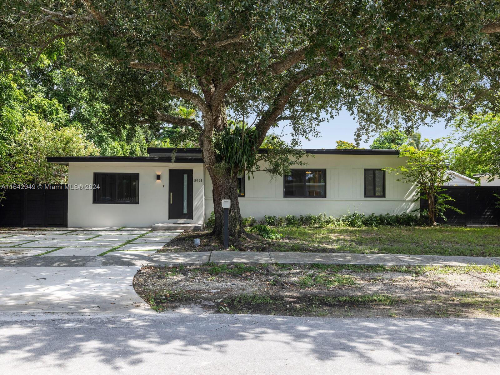 5991 Southwest 45th Street Miami, FL 33155 - Photo 9 of 35 a view of house with backyard and trees