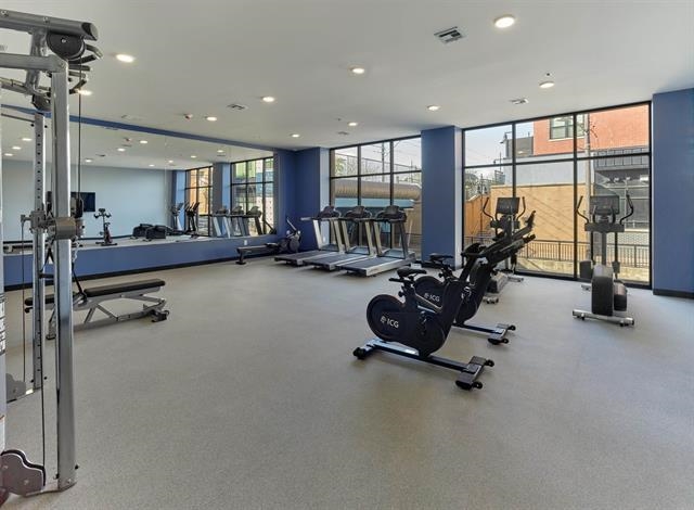 260 Ave East, Unit 609 Bayonne, NJ 07002 - Photo 18 of 24 a room with gym equipment and a large window