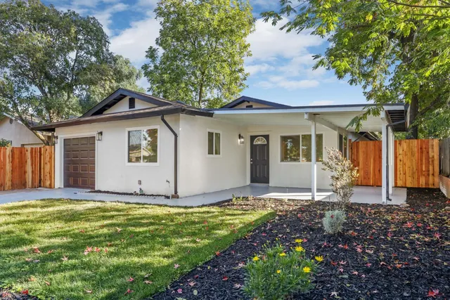 a view of a house with yard and sitting area