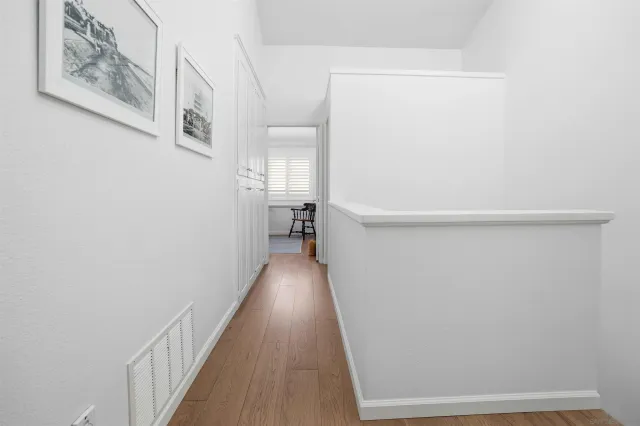 a view of a hallway with wooden floor and closet