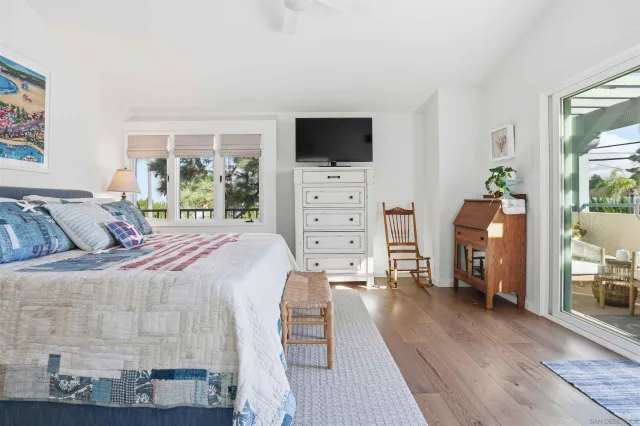 a bedroom with a bed and flat tv screen on the dresser