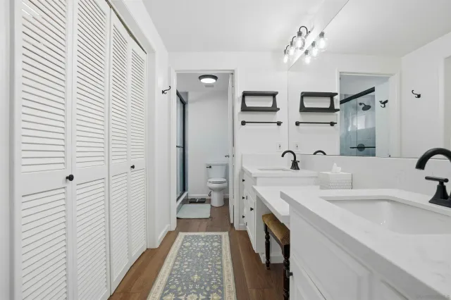 a spacious bathroom with a double vanity sink a mirror and a shower