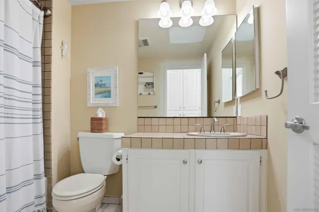 a bathroom with a sink a toilet and a mirror